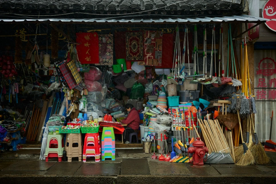 A cluttered storefront sells various household items and tools.